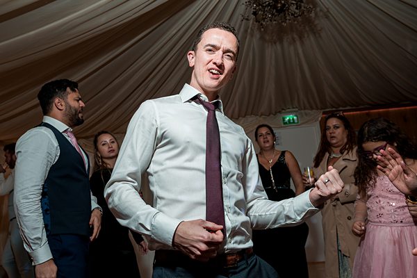 Man dancing at wedding reception.