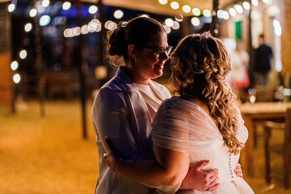 Couple embracing at evening outdoor wedding reception.