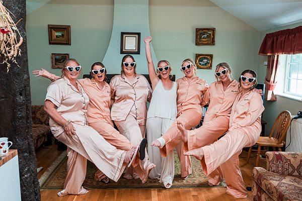 Women in matching outfits and sunglasses celebrating indoors.