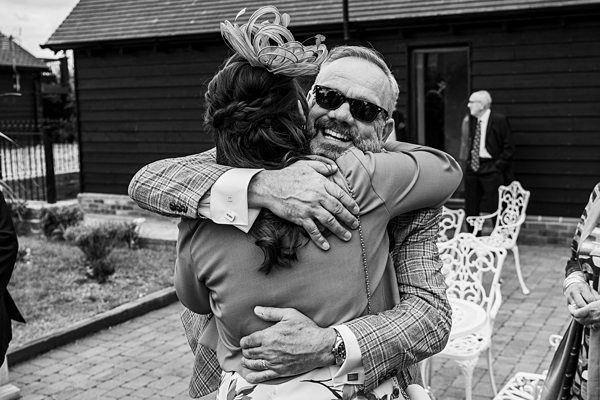 Joyful embrace at outdoor event in black and white.