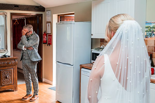 Emotional wedding day moment in kitchen setting.