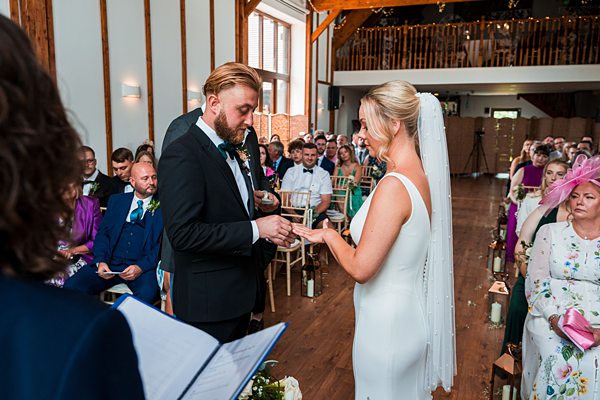 Bride and groom exchanging rings at wedding ceremony.