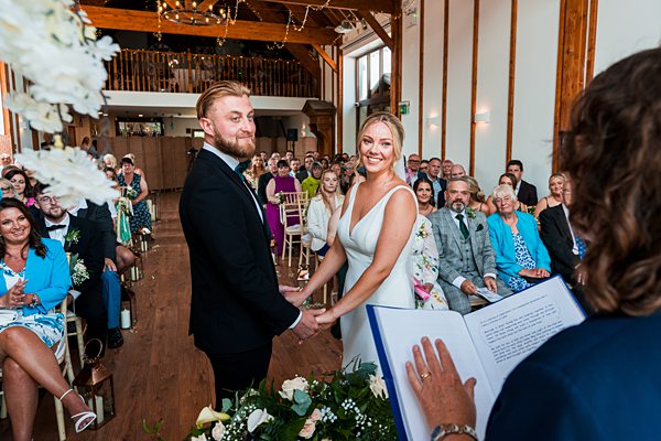 Couple exchanging vows in wedding ceremony with guests.