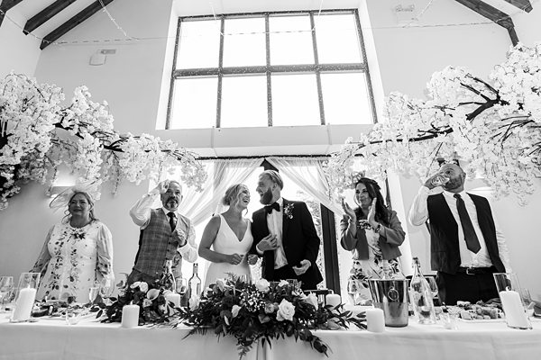 Wedding toast in elegant hall with floral decorations.