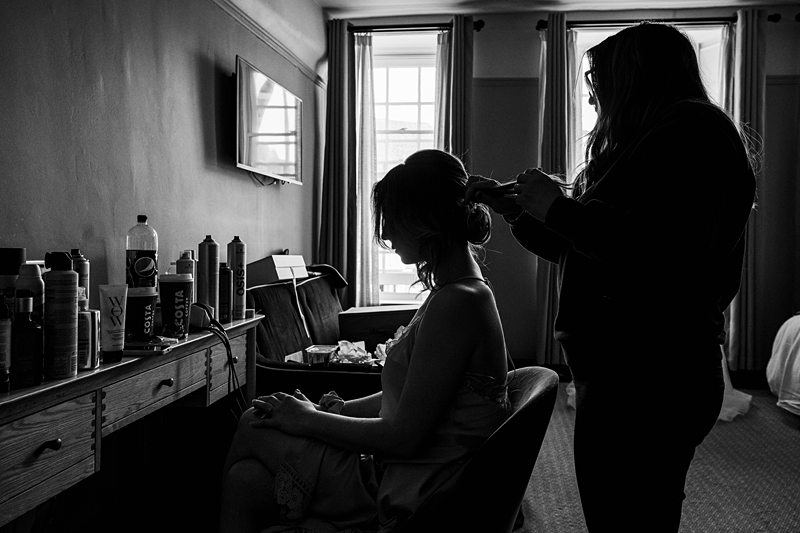 Bridal hair styling session in progress, monochrome photograph.
