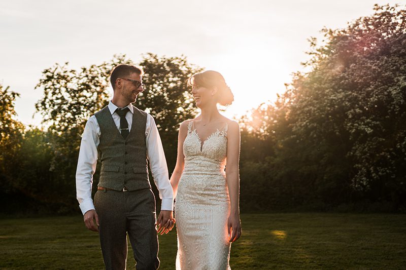 Couple walking in sunset-lit garden.