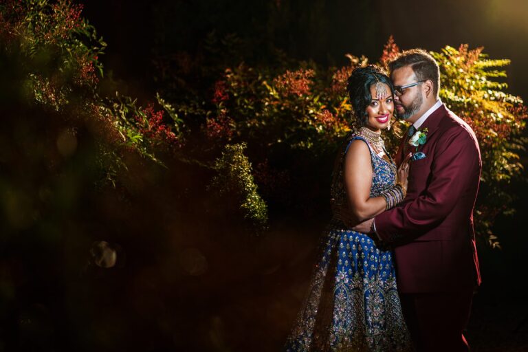 Couple posing in elegant attire at night.