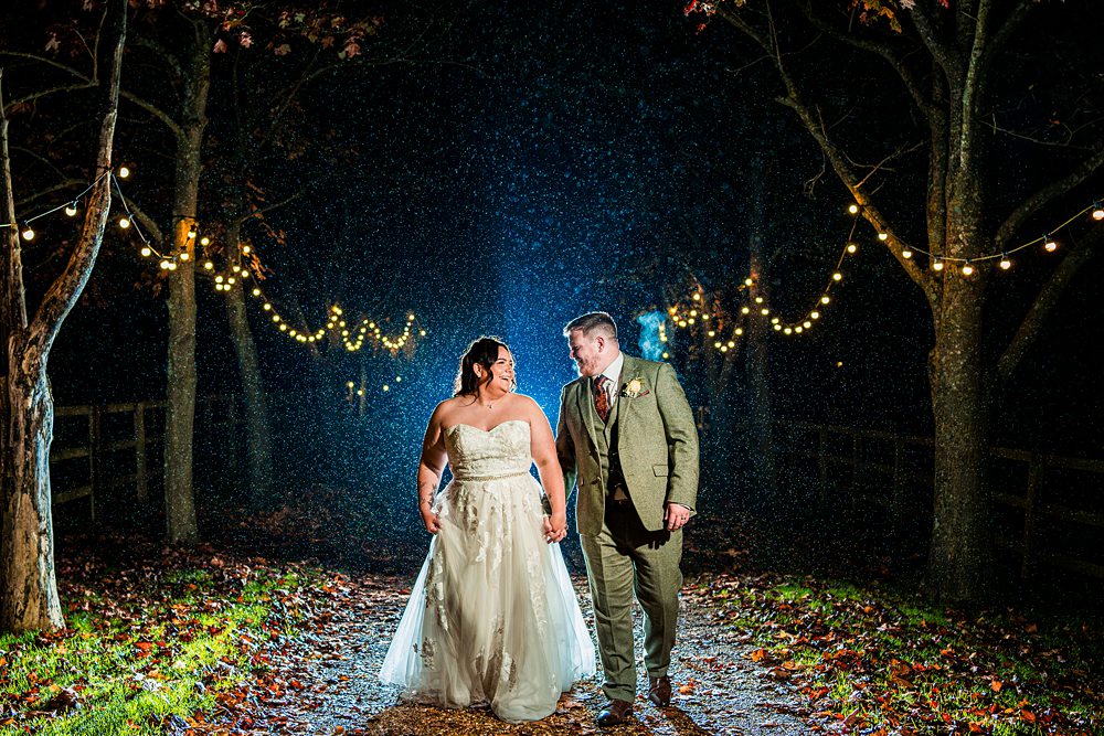 Rainy evening wedding couple under fairy lights