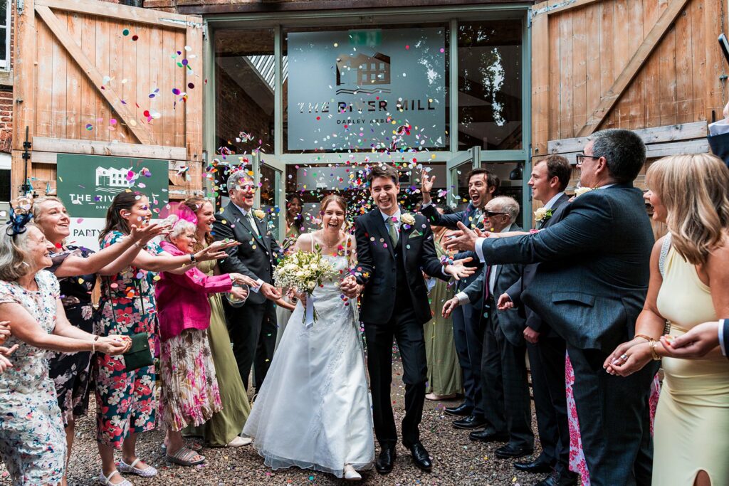 Bride and groom exiting with confetti celebration.