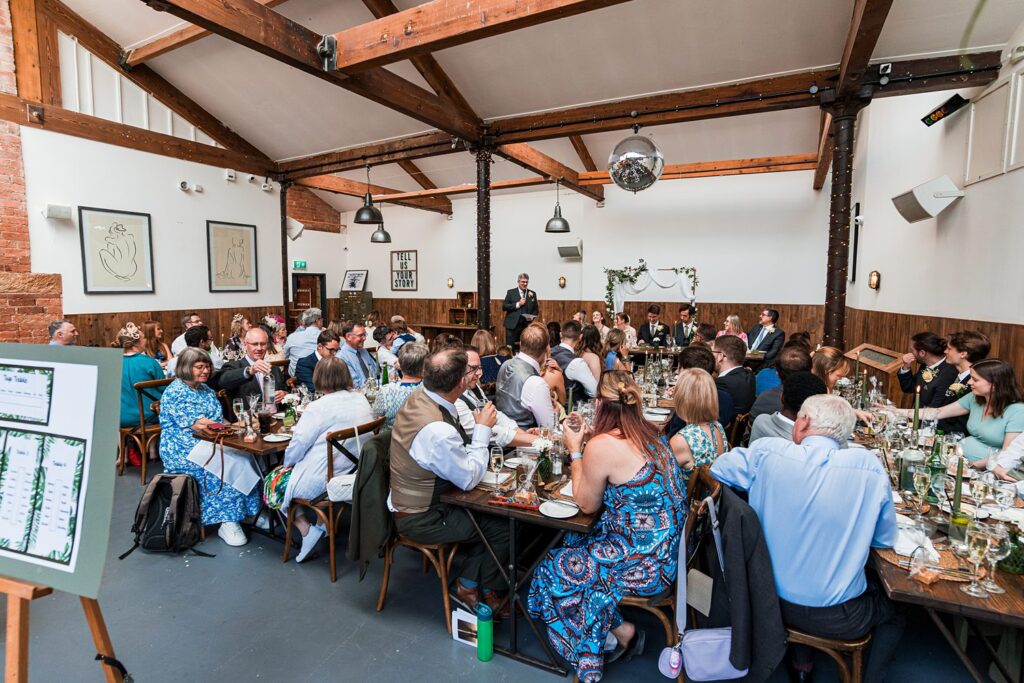 Wedding reception speech in rustic venue.