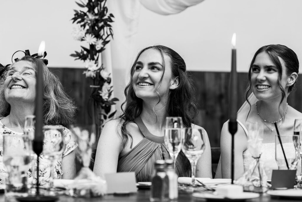 Three women smiling at a formal event