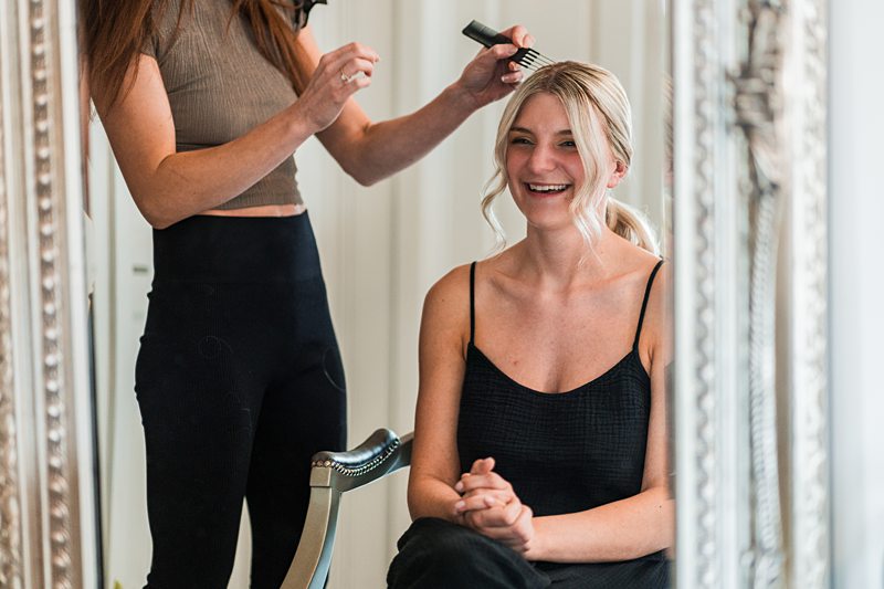 Hair stylist working on smiling woman
