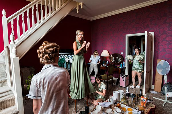 Bridesmaids getting ready in a lively room.