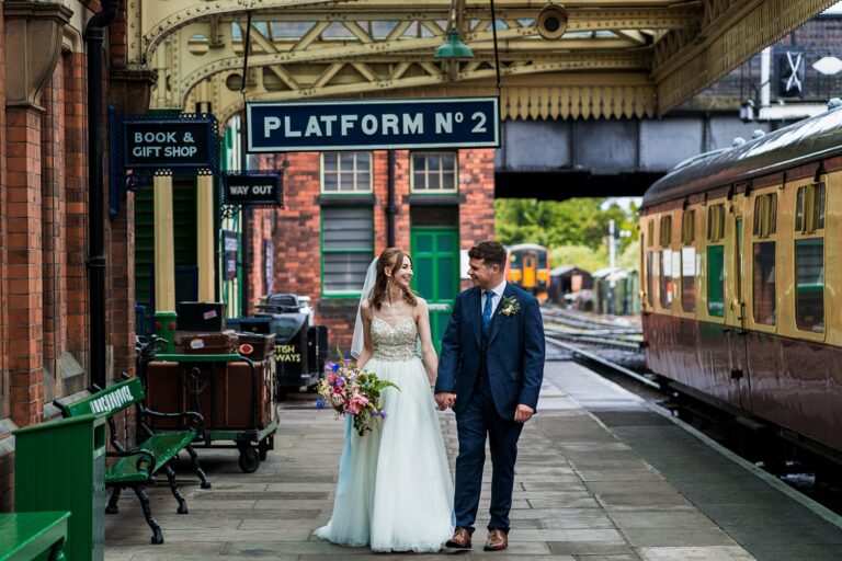 Bride and groom at vintage railway station.