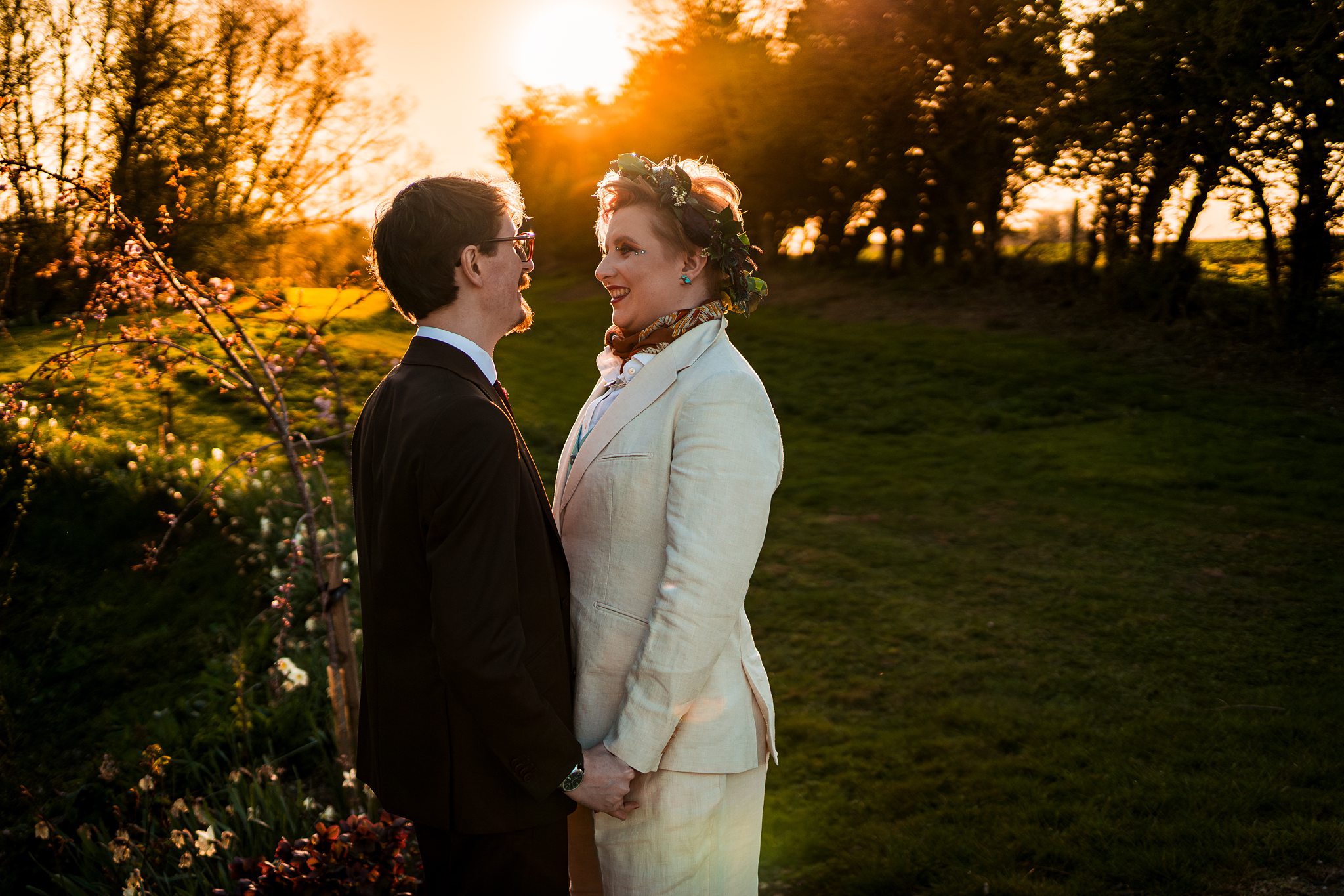 Couple smiling at sunset in a garden.