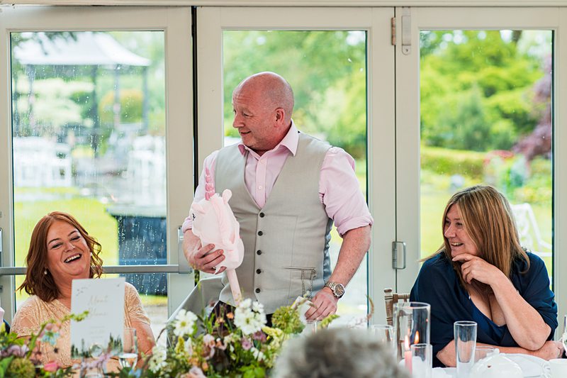 Man giving speech at cheerful gathering indoors.