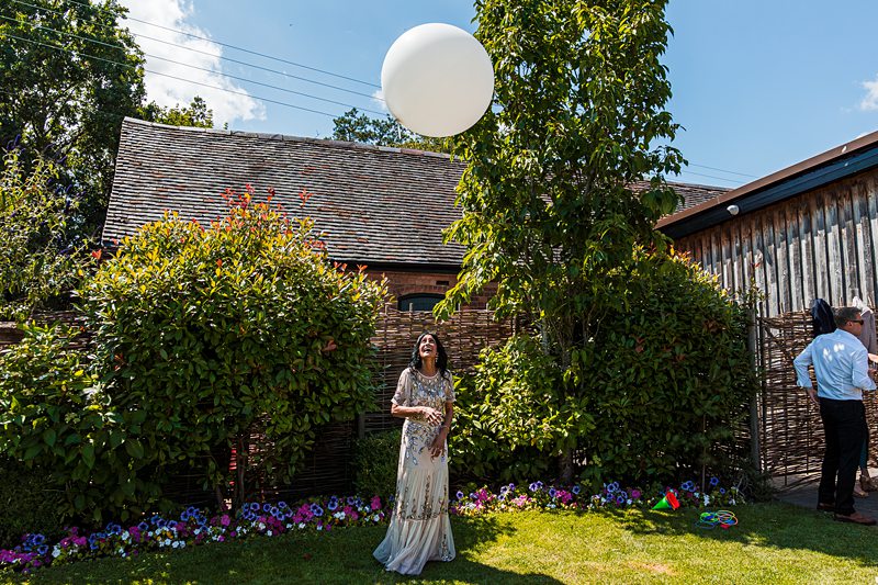 Woman in garden with large white balloon.