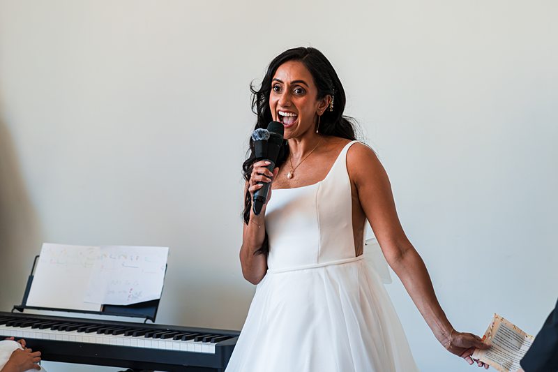 Woman in white dress speaking into microphone