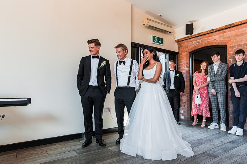 Bride and groom with guests during wedding reception.