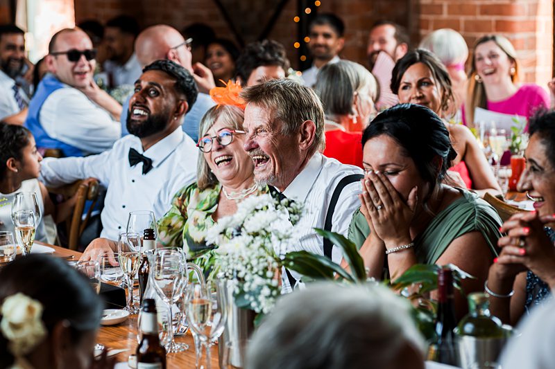 Guests laughing at a wedding reception.