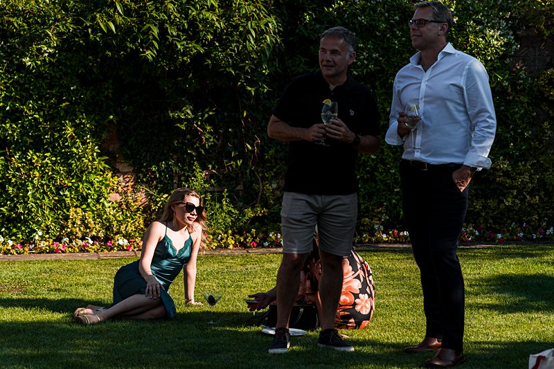 People enjoying a garden gathering with drinks.