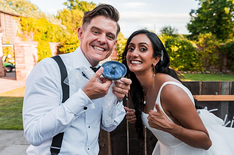 Smiling couple posing outdoors at wedding.