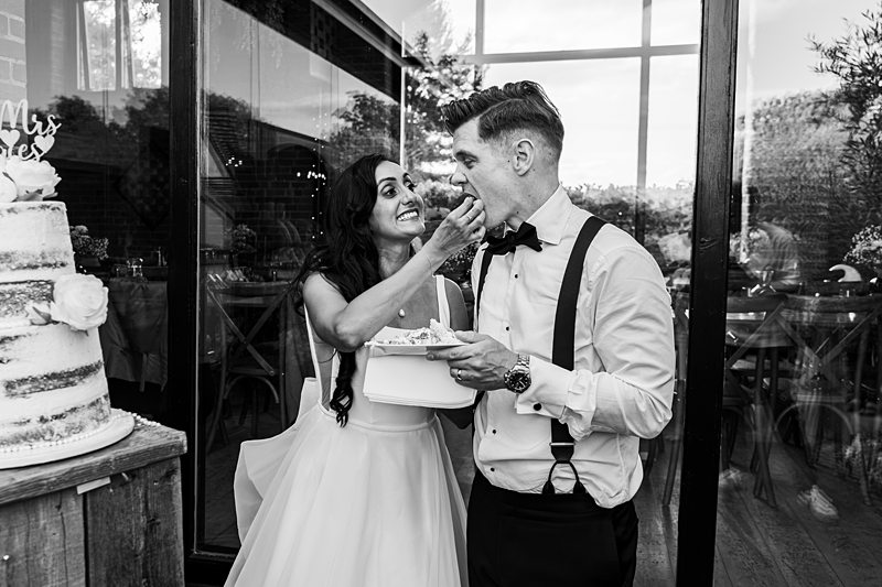 Bride and groom feeding each other wedding cake.