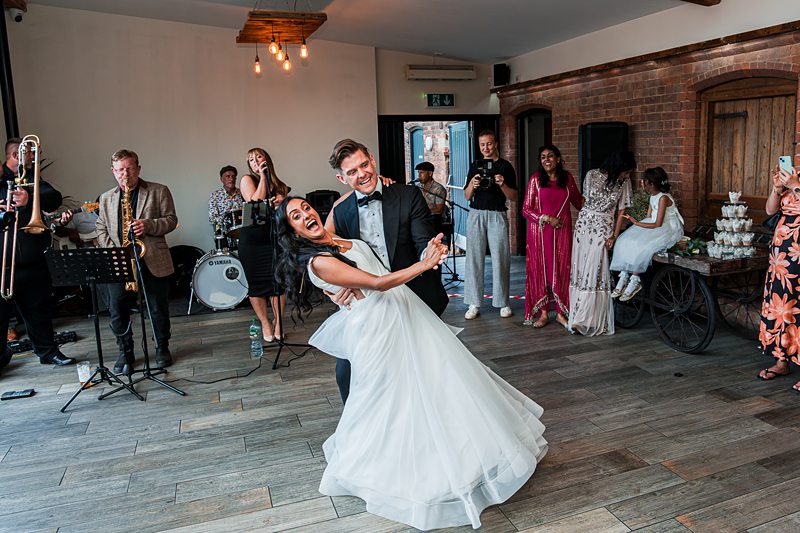 Couple dancing at wedding reception with live band.
