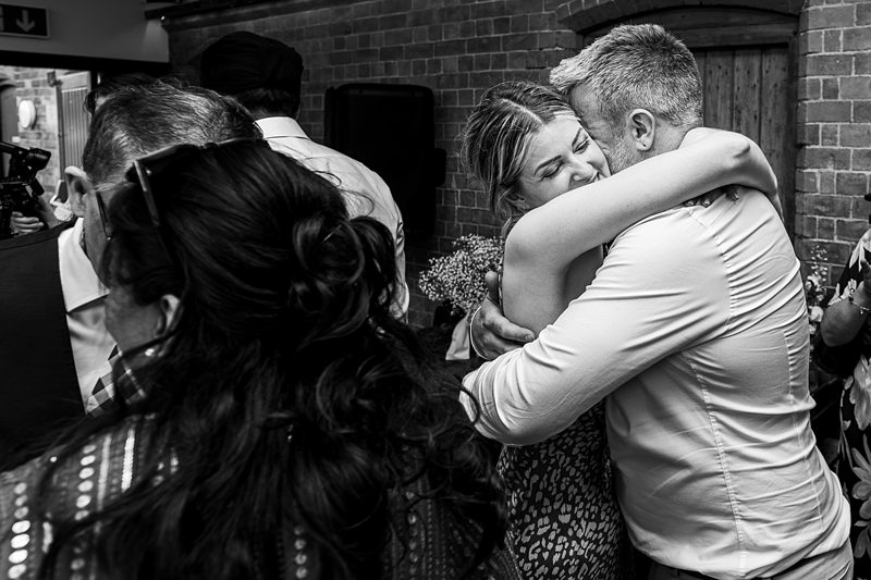 People hugging at a wedding celebration.