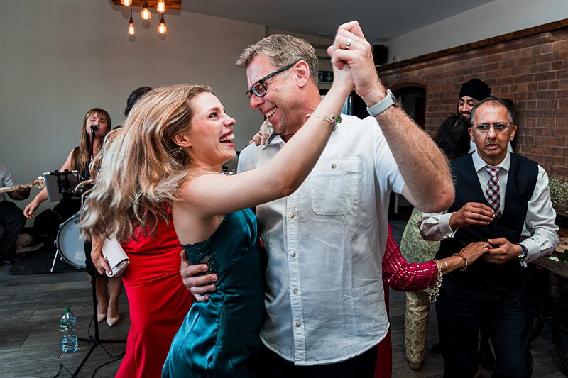 Couple joyfully dancing at a lively celebration.
