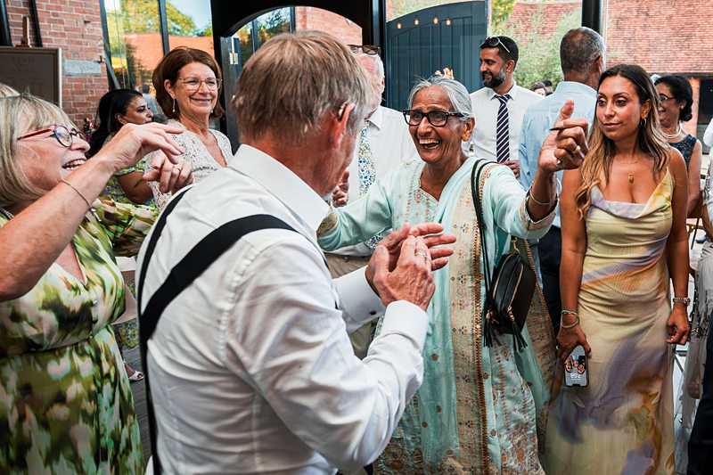 People joyfully dancing at an indoor party.