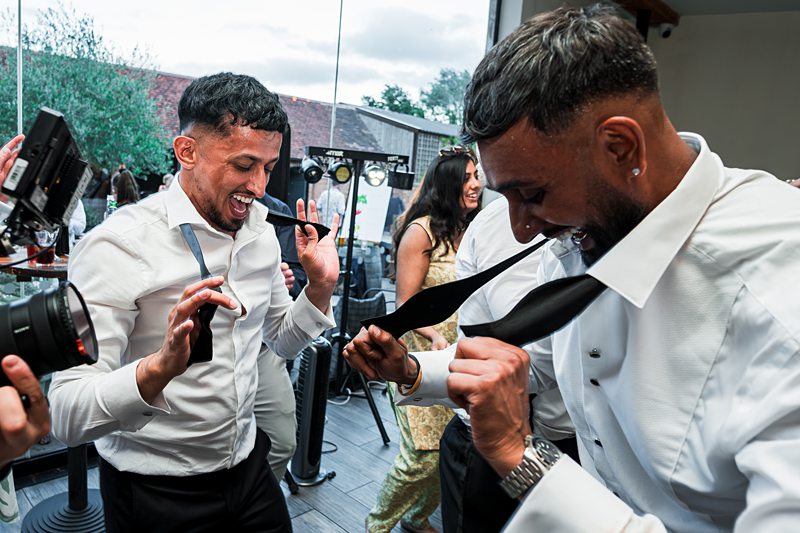 Men dancing joyfully at a wedding reception.