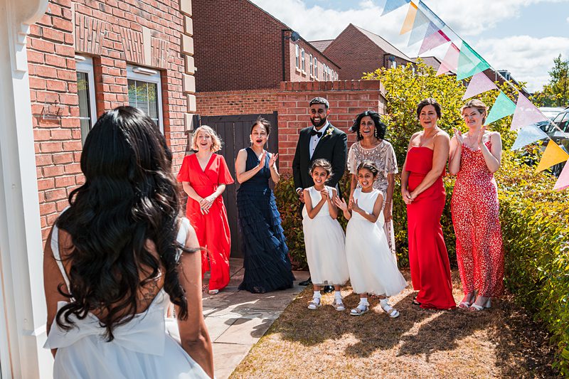 Bride approaches guests at outdoor wedding reception.