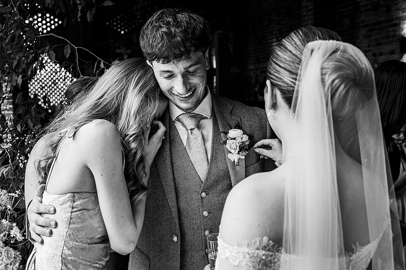 Smiling groom with friends on wedding day.