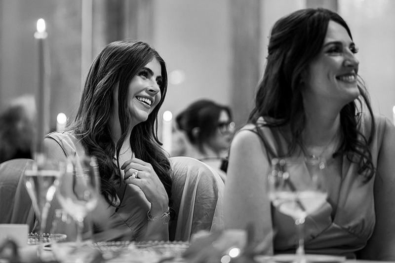 Smiling women at formal event with glasses.