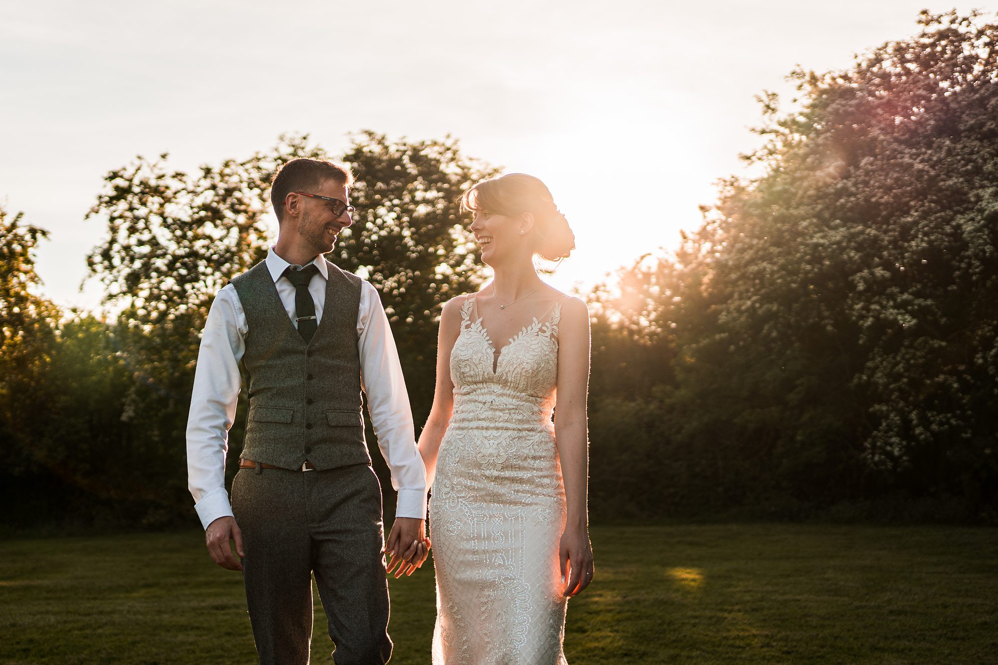 Newlyweds walking in sunset light.
