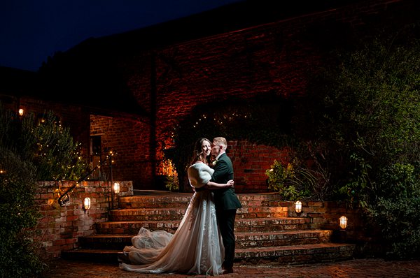 Couple embraces on lit steps at night