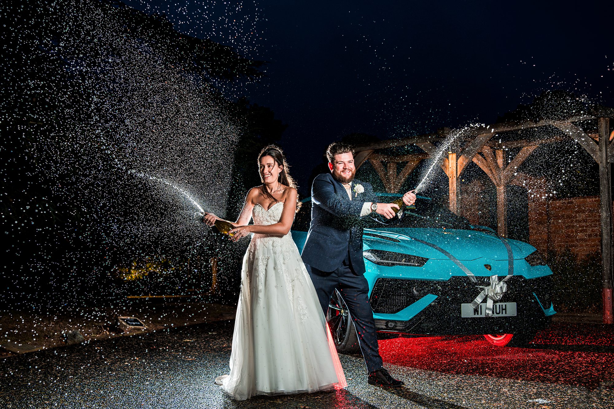 Bride and groom spraying champagne at night.