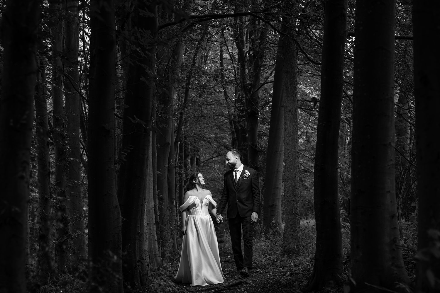 Bride and groom walking in dark forest