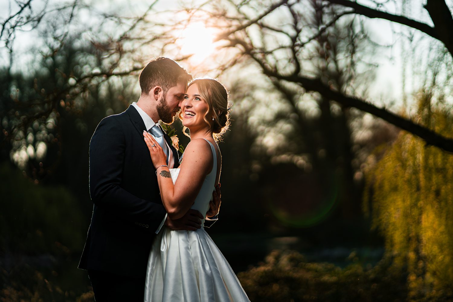 Bride and groom embracing at sunset outdoors