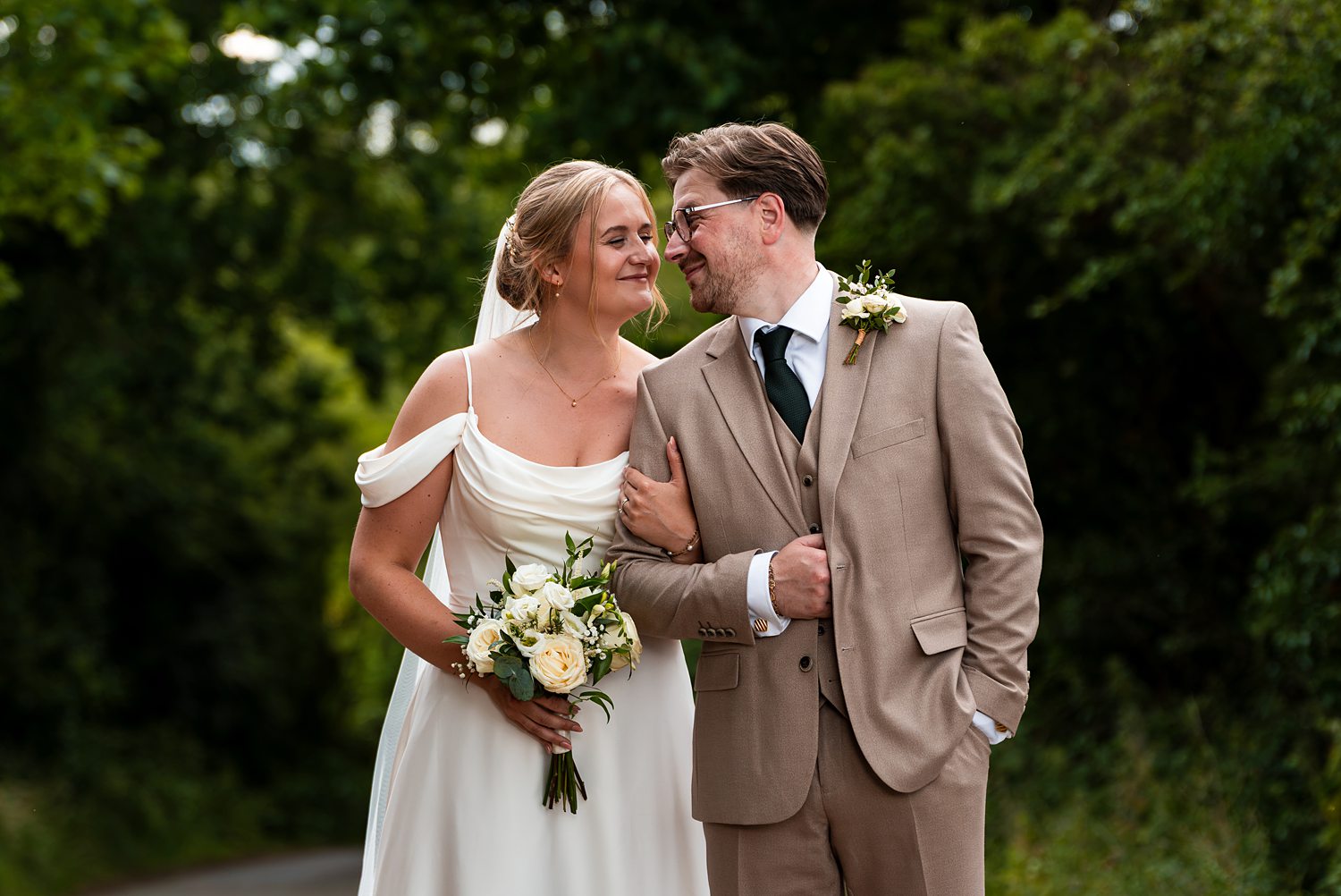 Bride and groom smiling outdoors on wedding day